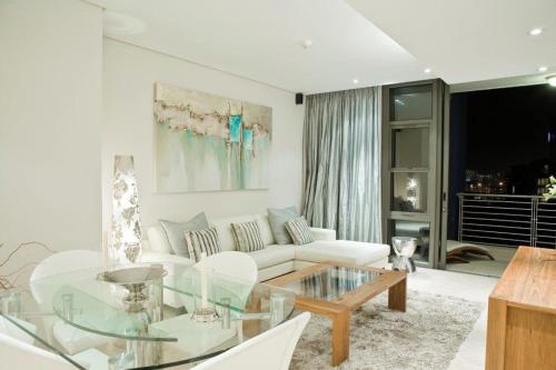 sala de estar con sofá blanco y mesa de cristal en Kylemore 405 B en Ciudad del Cabo