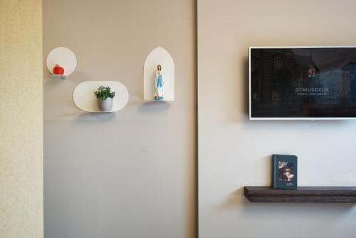 a wall with a tv and a shelf with a plant at Hotel Mariënhage in Eindhoven
