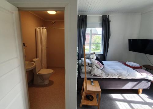 a bedroom with a bed and a bathroom with a mirror at HH&S Gåxsjö in Hammerdal