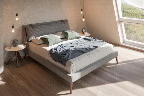 a bedroom with a bed in a room with a window at Marchegg Apartments in Naturno