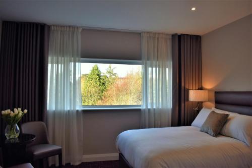 um quarto de hotel com uma cama e uma janela em The Birches Killarney em Killarney