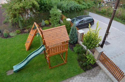 a playground with a wooden bench and a slide at Rekreačný dom Vyhne in Vyhne