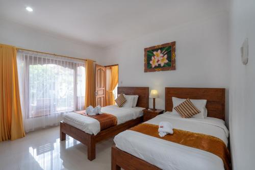 a hotel room with two beds and a window at Nusa Indah Bungalow in Nusa Lembongan