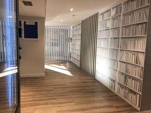 a hallway with a wall of bookshelves at ibis budget Paris Porte de Montreuil in Montreuil