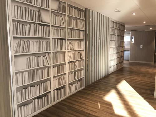 a wall of book shelves in a library at ibis budget Paris Porte de Montreuil in Montreuil