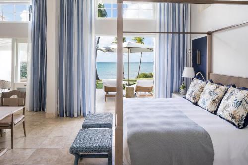 Cette chambre d'hôtel comprend un lit et offre une vue sur l'océan. dans l'établissement Jumby Bay Island - an Oetker Collection Hotel, à Saint Johnʼs