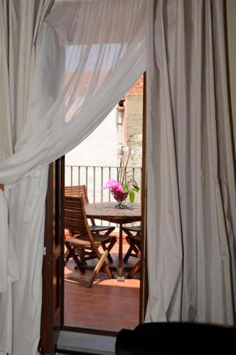 eine Terrasse mit einem Tisch und einem weißen Vorhang in der Unterkunft Cassisi Hotel in Milazzo