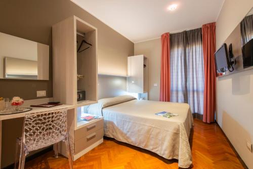 um quarto de hotel com uma cama, uma secretária e uma janela em Hotel Regent - In pieno Centro em San Benedetto del Tronto