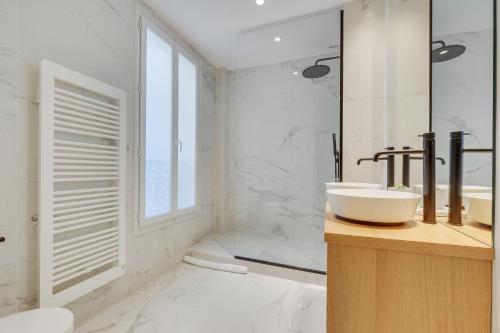 a white bathroom with a sink and a tub at Elegant Family Apt 5 pers - Bon Marché in Paris