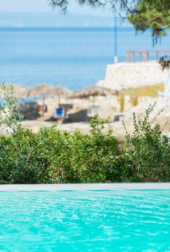 a swimming pool with a beach in the background at Akti Elia Villas Beachfront Chalkidiki in Elia