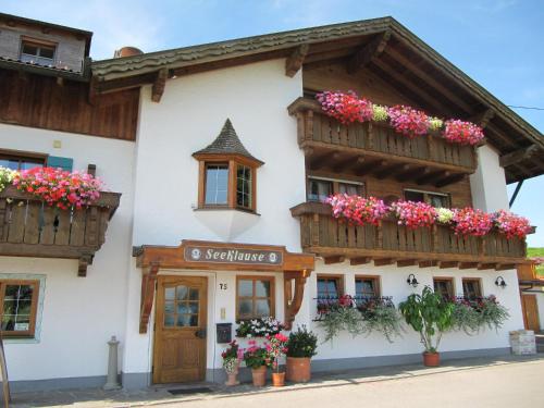 a building with flowerpots and wooden balconies on it at Gästehaus Seeklause in Schwangau