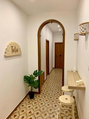 a hallway with an archway and a table and stools at Talìa in Agira