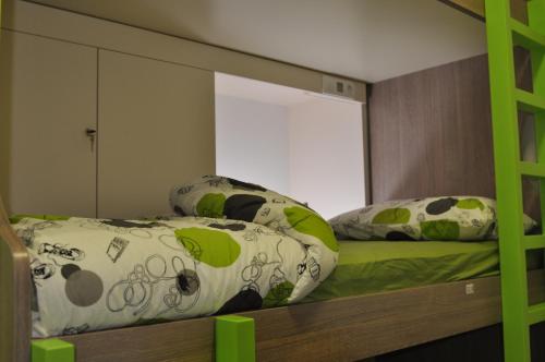 a bunk bed with two pillows on top of it at Hostel Tivoli in Ljubljana