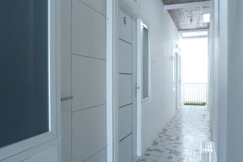 a hallway with white cabinets and a hallway with a window at Griya Joyo 2 Syariah in Malang