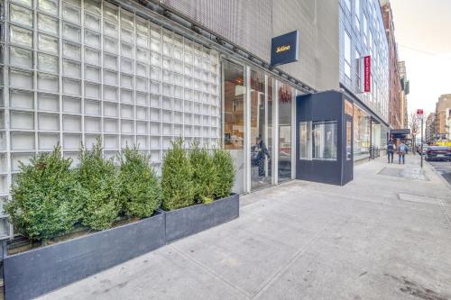 a store front of a building with potted plants on the sidewalk at Selina Chelsea in New York