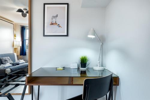 a desk with a lamp and a chair in a living room at HSA - Shoreditch in London
