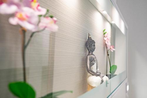 a small statue sitting on a shelf next to flowers at bedpark Stellingen in Hamburg