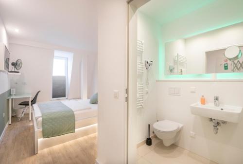 uma casa de banho com um WC, um lavatório e uma cama em bedpark Stellingen em Hamburgo