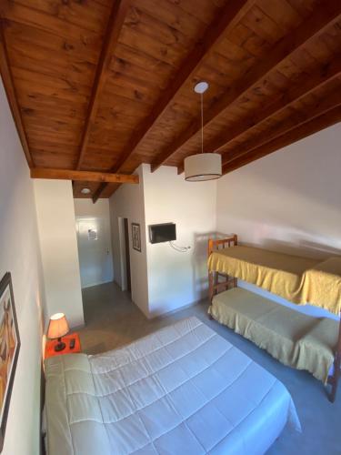 um quarto com uma cama grande e um tecto de madeira em Hotel y Cabañas Las Marías em El Calafate