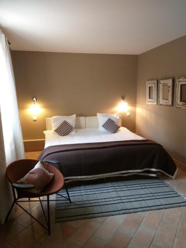une chambre avec un grand lit et une chaise dans l'établissement La Maison des Voyageurs, à Arles