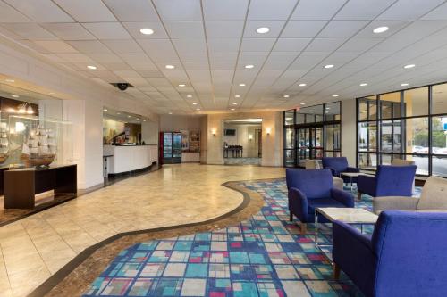a lobby with blue chairs and a rug at La Quinta by Wyndham Secaucus Meadowlands in Secaucus