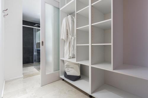 a white walk in closet with white shelves at Apartments and rooms Villa Bori in Poreč