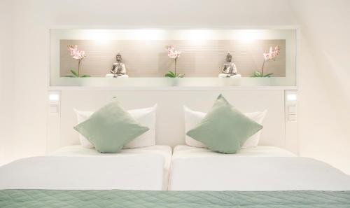 a white bed with white pillows and pink flowers on a shelf at bedpark Stellingen in Hamburg