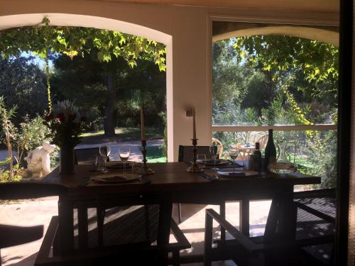 - une table dans une chambre avec 2 grandes fenêtres dans l'établissement La Maison des Voyageurs, à Arles