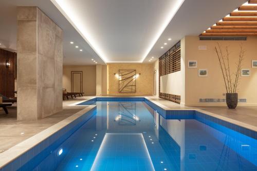 an indoor pool with blue water in a house at Orizontes Tzoumerkon Hotel Resort in Pramanta
