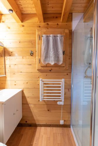 La salle de bains est pourvue d'une douche et d'une serviette. dans l'établissement Chalet Mahana, aux Gets