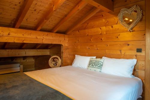 - une chambre avec un lit dans une pièce en bois dans l'établissement Chalet Mahana, aux Gets