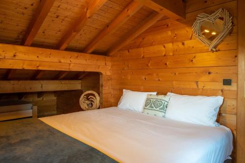 une chambre avec un lit dans une pièce en bois dans l'établissement Chalet Mahana, aux Gets