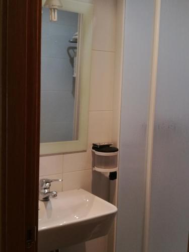 a bathroom with a sink and a mirror at Pension Santiago in Burgos