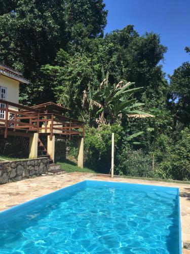 ein blauer Pool vor einem Haus in der Unterkunft Pousada Casa da Montanha in Angra dos Reis