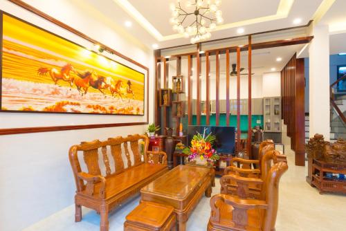 a lobby with wooden benches and a painting on the wall at Bill Ben Homestay Hoi An in Hoi An