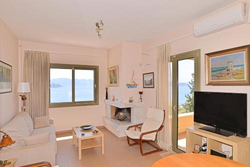 a living room with a couch and a tv at Cozy Sunset House in Aegina Town