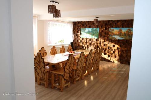 a dining room with a wooden table and chairs at Cabana Ioana in Voronet