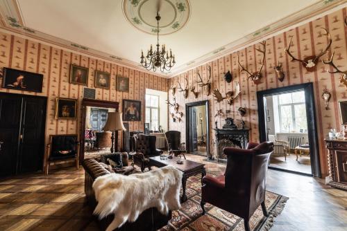 a living room filled with furniture and a chandelier at Burbiskio dvaras in Anykščiai