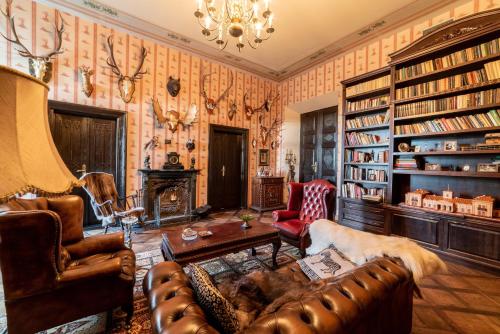 - un salon avec des meubles en cuir et des étagères dans l'établissement Burbiskio dvaras, à Anykščiai