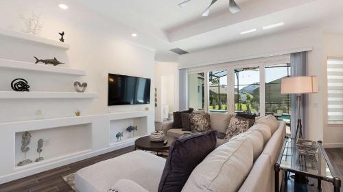 sala de estar con sofá y TV en Paradise at Providence - Exclusive 4 bed pool home en Orlando