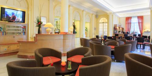 un hall d'entrée avec des chaises et des tables et un bar dans l'établissement Hotel El Paradiso, à Menton