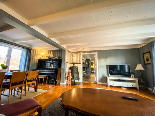 Una sala de estar con una mesa y un televisor. en Villa Edvin - Slow living, en Eide