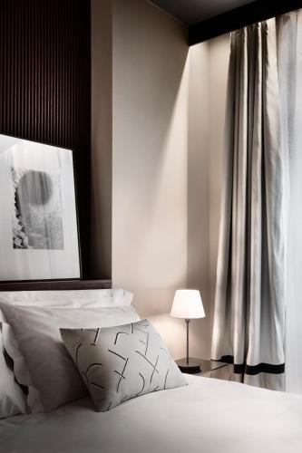 a bedroom with a white bed with a black headboard at Speronari Suites in Milan