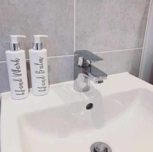 two bottles ofodorizers sitting on top of a sink at Modern Queens Quarter Townhouse 2 in Belfast