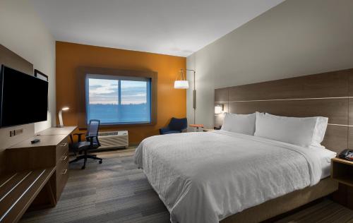 Un pat sau paturi într-o cameră la Holiday Inn Express & Suites - Fayetteville South, an IHG Hotel