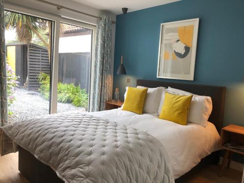 a bedroom with a large bed with yellow pillows at Beautiful Coastal Cottage in Pittenweem in Pittenweem