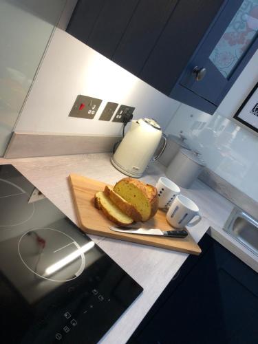 a cutting board with a piece of cake on a counter at Beautiful Coastal Cottage in Pittenweem in Pittenweem