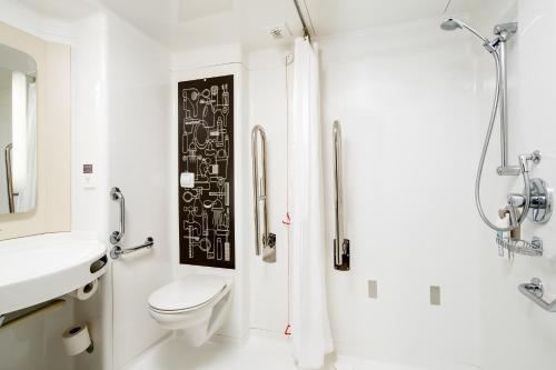 a bathroom with a toilet and a sink and a shower at ibis London City - Shoreditch in London