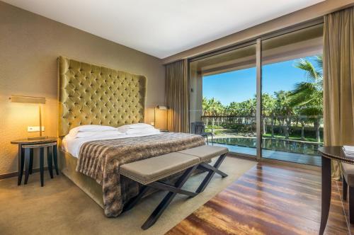 a bedroom with a large bed and a large window at AP Lago Montargil - Conference & SPA in Montargil