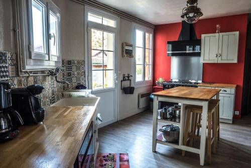a kitchen with red walls and a wooden counter top at LE JABLOIRE in Florent-en-Argonne